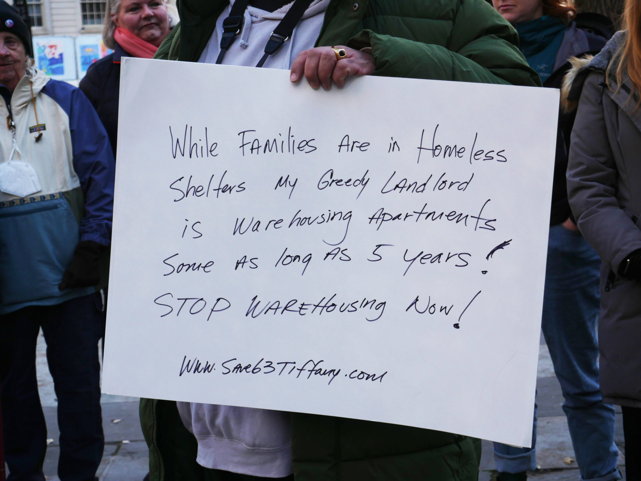 John Levya, housing activist, holding a sign at the rally
